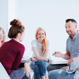 Smiling group of teenagers during meeting with personality couch helping get them self-confidence